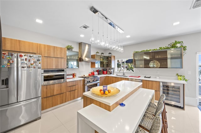 kitchen with beverage cooler, a center island, exhaust hood, stainless steel appliances, and a breakfast bar