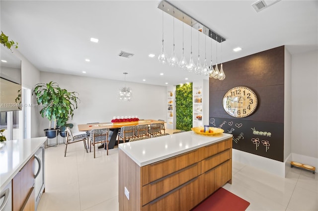 interior space featuring decorative light fixtures, a spacious island, an inviting chandelier, and light tile patterned flooring