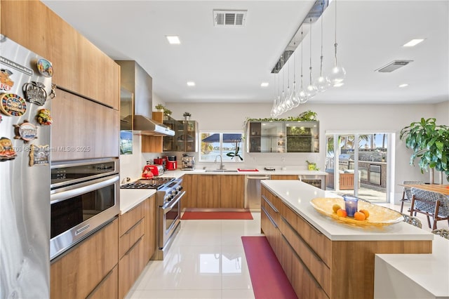 kitchen featuring a spacious island, appliances with stainless steel finishes, extractor fan, sink, and light tile patterned floors