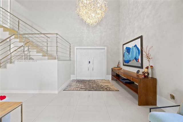 tiled entryway featuring an inviting chandelier and a towering ceiling