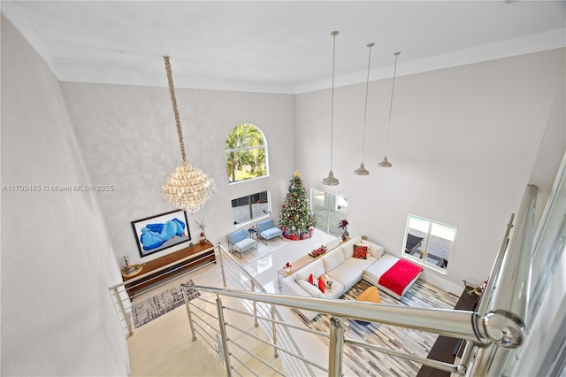 living room featuring a towering ceiling and a notable chandelier