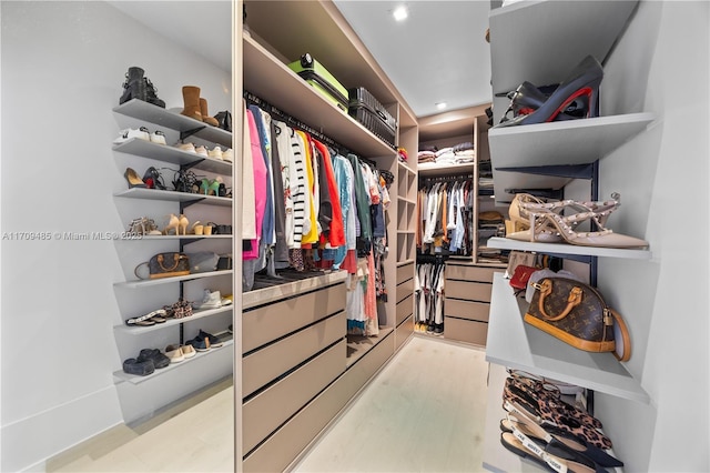 walk in closet with light hardwood / wood-style flooring