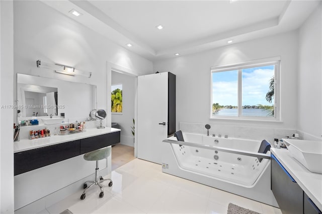 bathroom with a raised ceiling, vanity, and a washtub