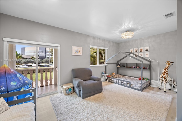 bedroom featuring an inviting chandelier and hardwood / wood-style floors