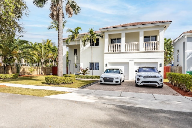 mediterranean / spanish house with a balcony, a front lawn, and a garage