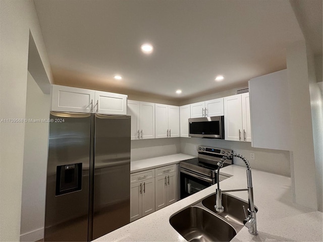 kitchen with white cabinets, appliances with stainless steel finishes, and sink