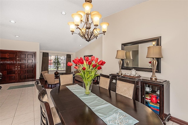 dining room featuring lofted ceiling, light tile patterned floors, and an inviting chandelier