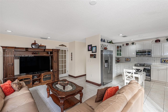 living room with light tile patterned floors and a textured ceiling