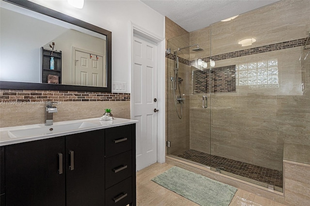 bathroom with vanity, wood-type flooring, a shower with shower door, and tile walls