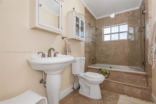 bathroom featuring tile patterned flooring, tiled shower / bath combo, toilet, and crown molding