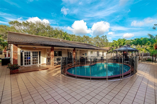 view of swimming pool with a gazebo, ceiling fan, a patio, and french doors