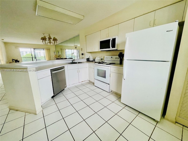 kitchen featuring kitchen peninsula, white appliances, sink, light tile patterned floors, and white cabinetry