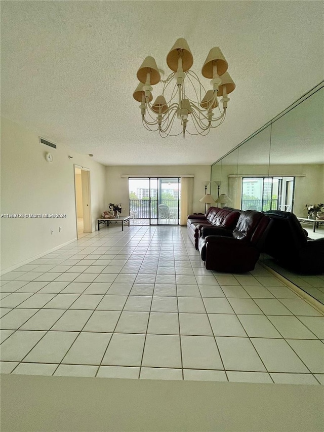 tiled living room with a textured ceiling and a chandelier