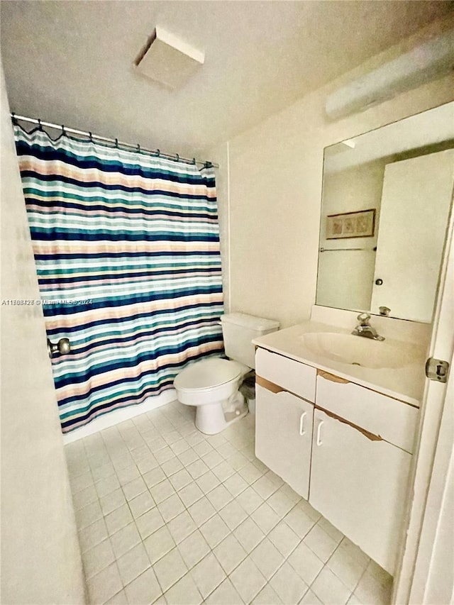 bathroom with tile patterned flooring, vanity, toilet, and a shower with shower curtain