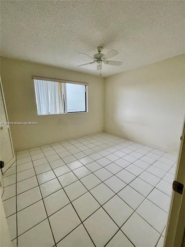 tiled spare room featuring ceiling fan and a textured ceiling