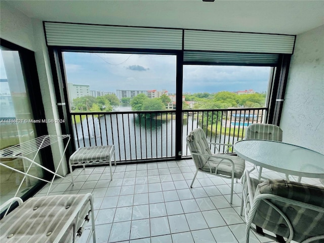 sunroom featuring plenty of natural light and a water view