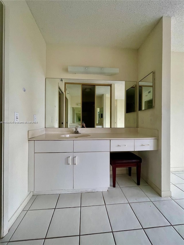 bathroom featuring tile patterned flooring, vanity, and a textured ceiling