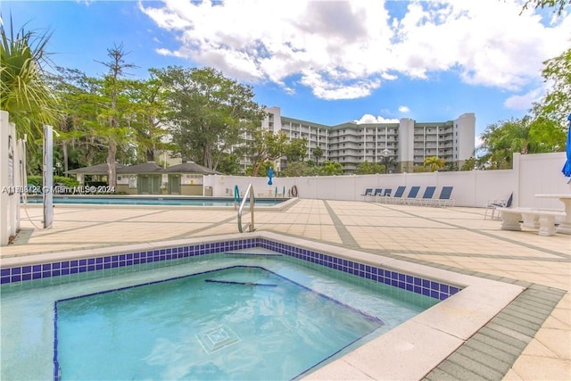 view of pool with a patio and a hot tub