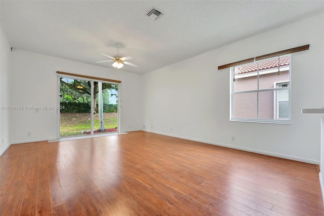 spare room featuring a textured ceiling, light hardwood / wood-style flooring, and ceiling fan