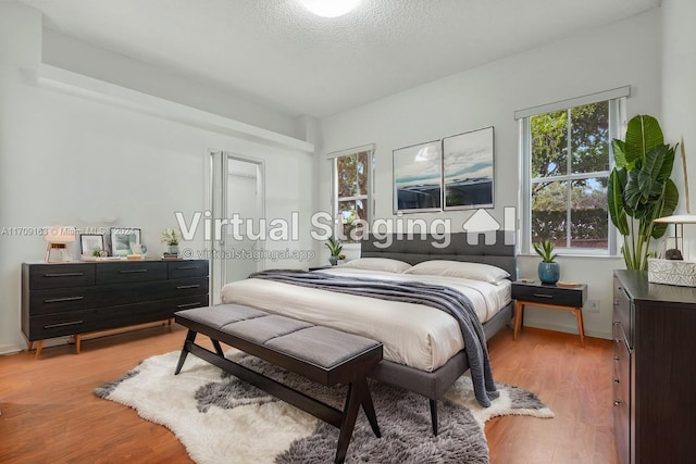 bedroom featuring a textured ceiling and light wood-type flooring