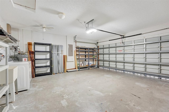 garage with electric panel, ceiling fan, a garage door opener, and separate washer and dryer