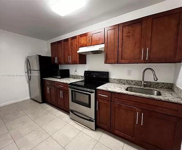 kitchen featuring light stone countertops, sink, light tile patterned floors, and stainless steel appliances