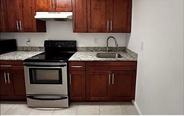 kitchen featuring light stone counters, stainless steel electric range oven, sink, and light tile patterned floors