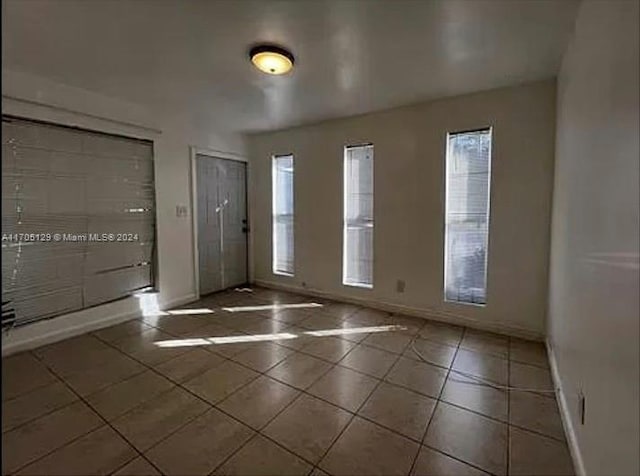 unfurnished room featuring dark tile patterned floors