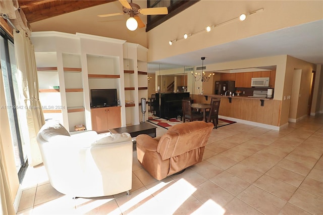 tiled living room featuring beam ceiling, ceiling fan with notable chandelier, and high vaulted ceiling