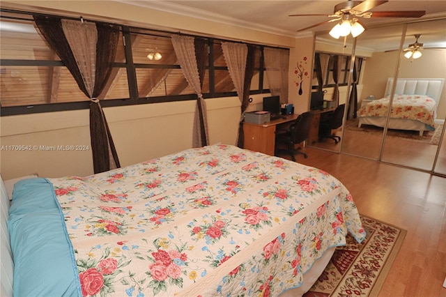 bedroom with a closet, hardwood / wood-style floors, ceiling fan, and crown molding