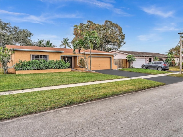 ranch-style house featuring a front lawn and a garage