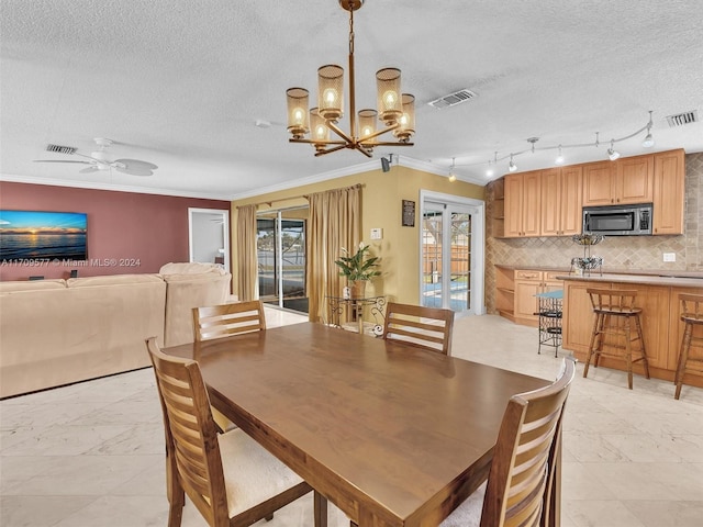 dining room with ceiling fan with notable chandelier, a textured ceiling, and ornamental molding