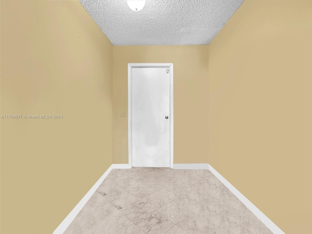 spare room with a textured ceiling