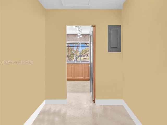 hall with a textured ceiling, electric panel, and sink