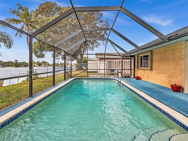 view of swimming pool featuring a lawn and a lanai