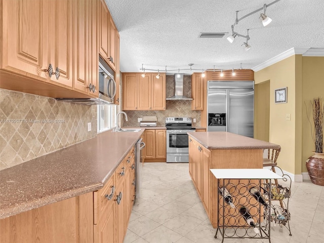 kitchen with a center island, sink, wall chimney exhaust hood, stainless steel appliances, and crown molding