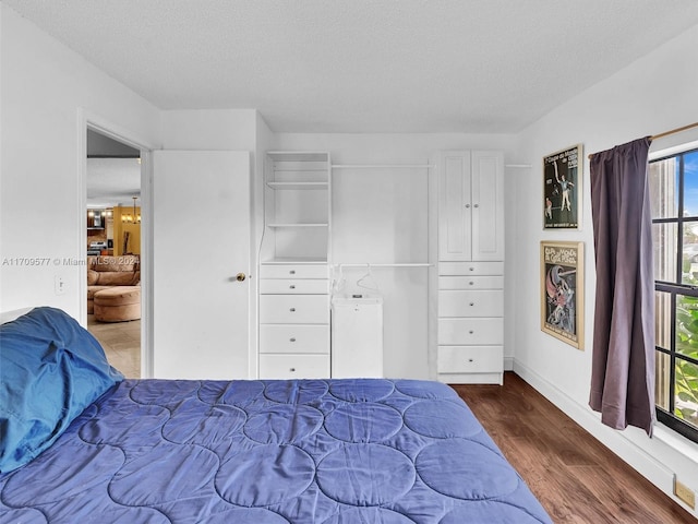 bedroom with a textured ceiling and dark wood-type flooring