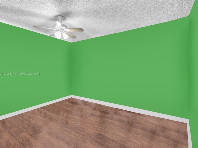 empty room featuring wood-type flooring, a textured ceiling, and ceiling fan