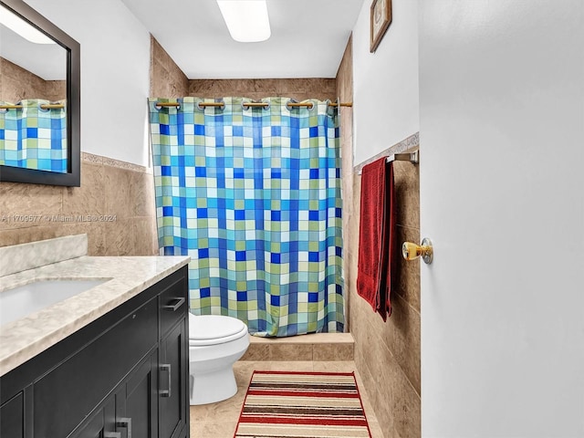 bathroom with a shower with curtain, vanity, tile walls, tile patterned flooring, and toilet