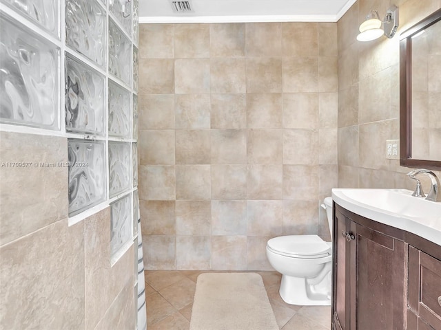 bathroom with vanity, tile patterned floors, tile walls, and ornamental molding