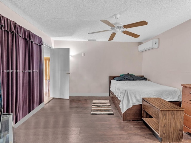 bedroom featuring ceiling fan, dark hardwood / wood-style flooring, a textured ceiling, and a wall mounted AC