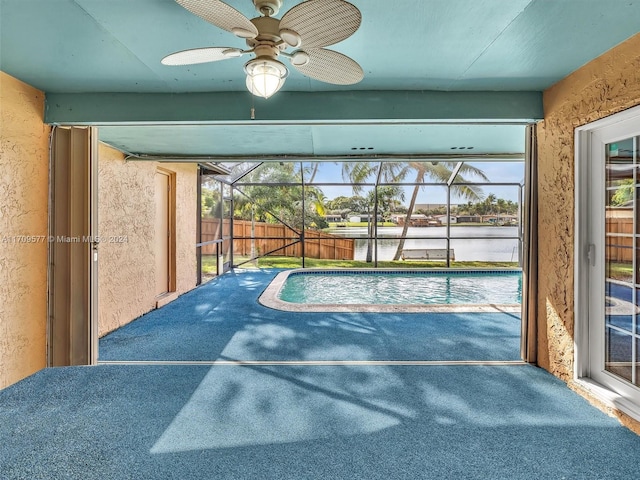 sunroom featuring a water view, a pool, a wealth of natural light, and ceiling fan