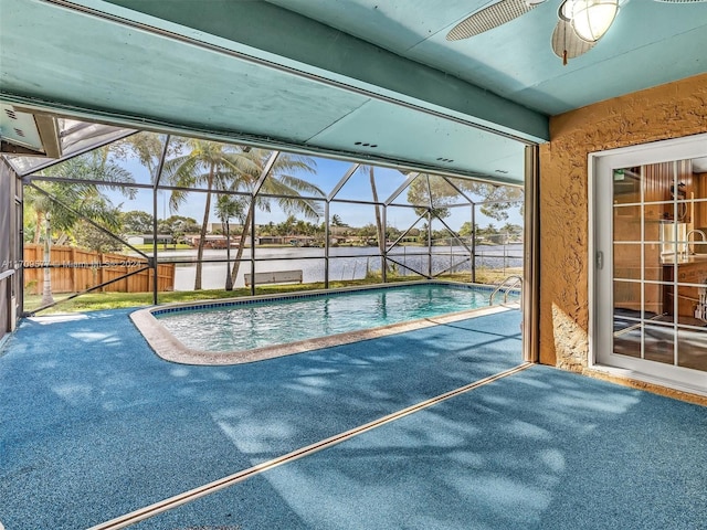 view of swimming pool with glass enclosure, ceiling fan, and a water view