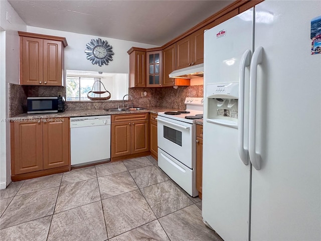 kitchen with decorative backsplash, white appliances, and sink