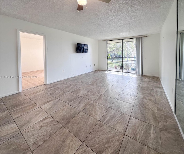 unfurnished room featuring floor to ceiling windows, ceiling fan, wood-type flooring, and a textured ceiling