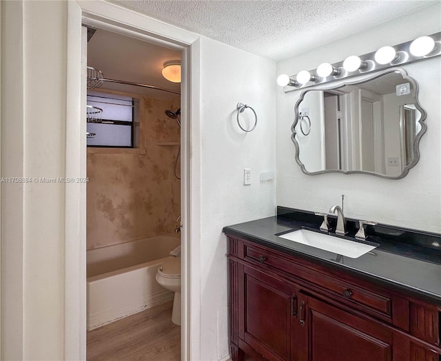 full bathroom with vanity, a textured ceiling, shower / bathing tub combination, wood-type flooring, and toilet