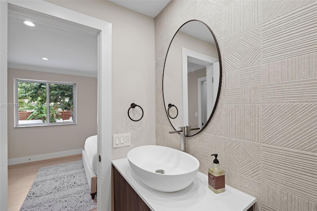 bathroom with vanity, hardwood / wood-style floors, and ornamental molding