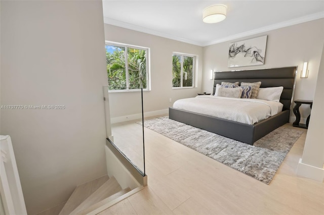 bedroom with ornamental molding and light hardwood / wood-style floors