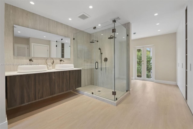 bathroom with a shower with shower door, tasteful backsplash, hardwood / wood-style flooring, vanity, and french doors