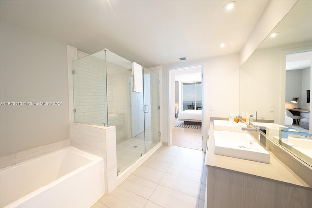 bathroom featuring tile patterned flooring, vanity, and shower with separate bathtub